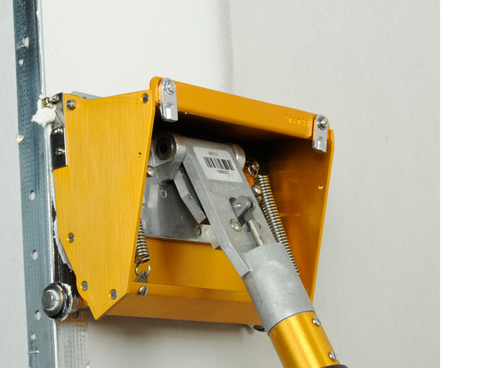 Close-up of a TapeTech finishing box attached to a box handle applying mud to metal corner bead